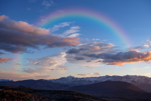 Hermoso paisaje con arco iris y nubes