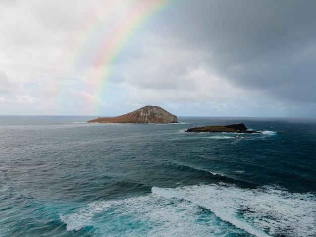 Hermoso paisaje con arco iris y océano.