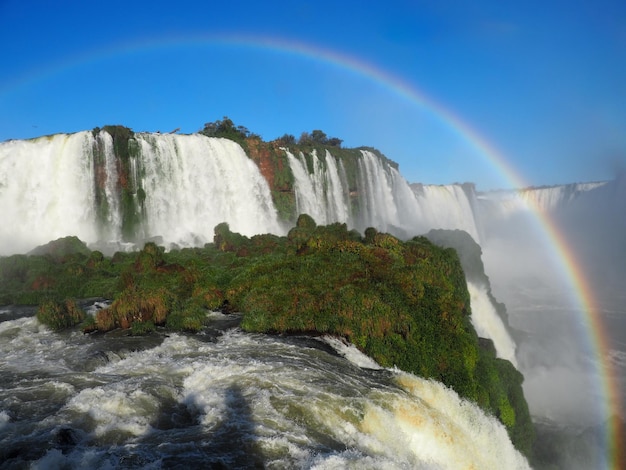 Foto gratuita hermoso paisaje de un arco iris sobre una cascada en el parque nacional iguazú, cataratas, argentina