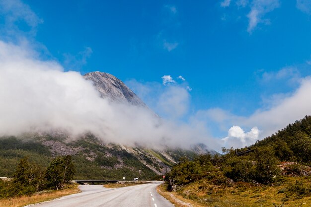 Hermoso paisaje con camino sinuoso en las montañas con nubes