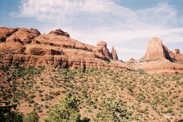 Hermoso paisaje de cañones rocosos rodeados de arbustos bajo el impresionante cielo nublado