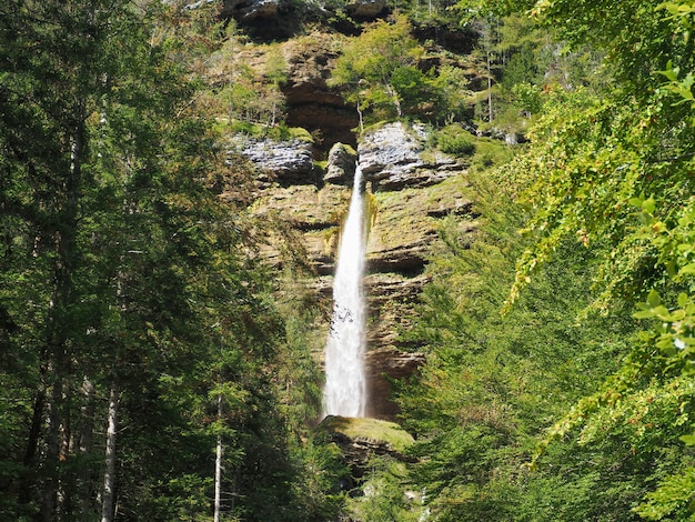 Hermoso paisaje de la cascada que atraviesa las rocas cubiertas de musgo en el bosque