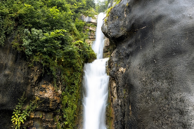 Hermoso paisaje de una cascada que fluye a través de acantilados rocosos