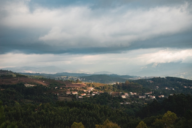 Hermoso paisaje de una ciudad escondida entre los árboles en una zona montañosa