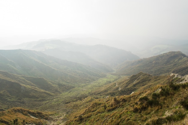 Hermoso paisaje de una cordillera de verdes montañas envueltas en niebla