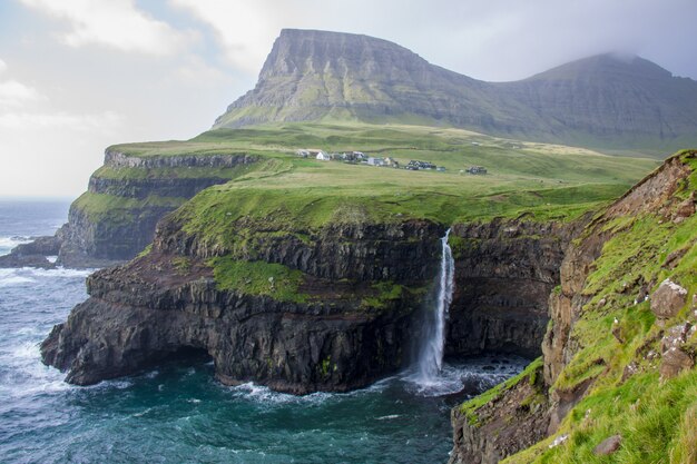 Hermoso paisaje de una costa rocosa cubierta de vegetación junto a un cuerpo de agua