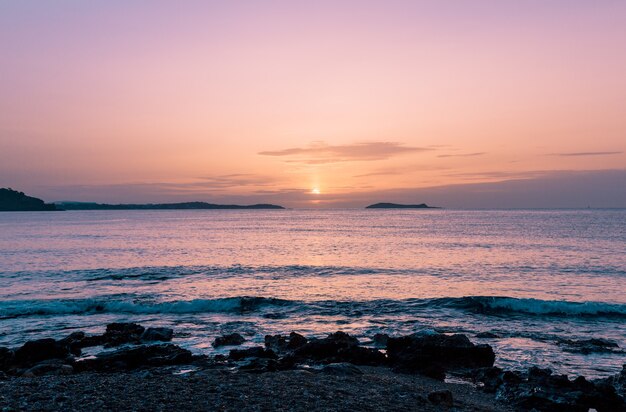 Hermoso paisaje de una costa rocosa y un mar durante la puesta de sol