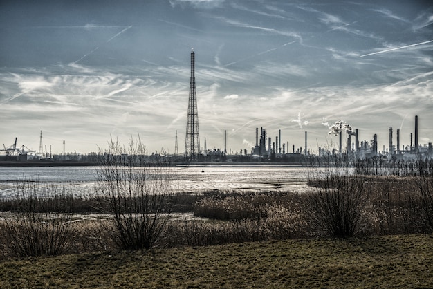 Hermoso paisaje de edificios industriales en la costa rodeados de hierba bajo un cielo impresionante