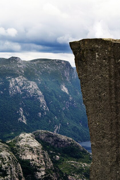 Hermoso paisaje de los famosos acantilados de Preikestolen cerca de un lago bajo un cielo nublado en Stavanger, Noruega