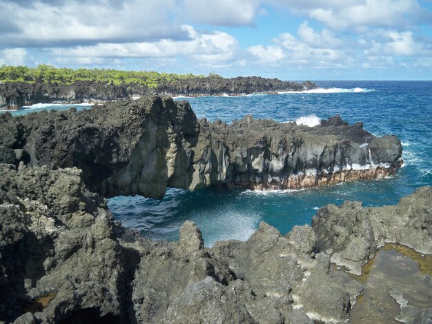 Hermoso paisaje de formaciones rocosas afiladas en la playa bajo el cielo nublado en Hawai