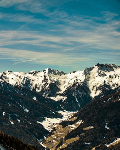 Hermoso paisaje de una gama de montañas rocosas cubiertas de nieve bajo un cielo nublado