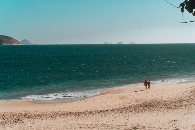 Hermoso paisaje de gente caminando por la playa en Río de Janeiro.