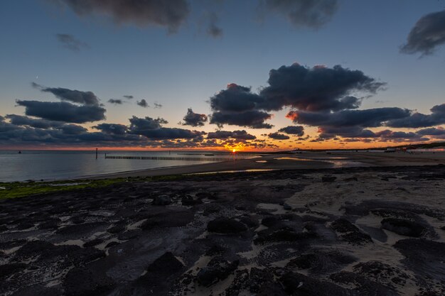 Hermoso paisaje de una impresionante puesta de sol sobre el océano tranquilo en Westkapelle, Zelanda