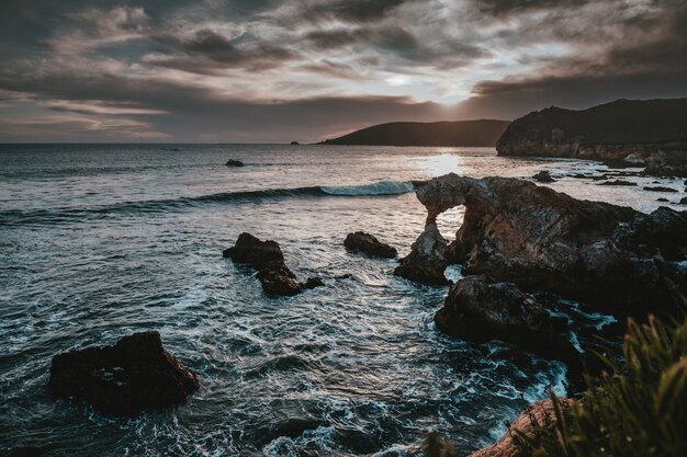 Hermoso paisaje del mar con acantilados, arrecifes, rocas e impresionantes nubes en el cielo