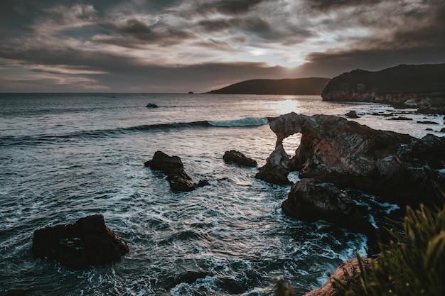 Hermoso paisaje del mar con acantilados, arrecifes, rocas e impresionantes nubes en el cielo