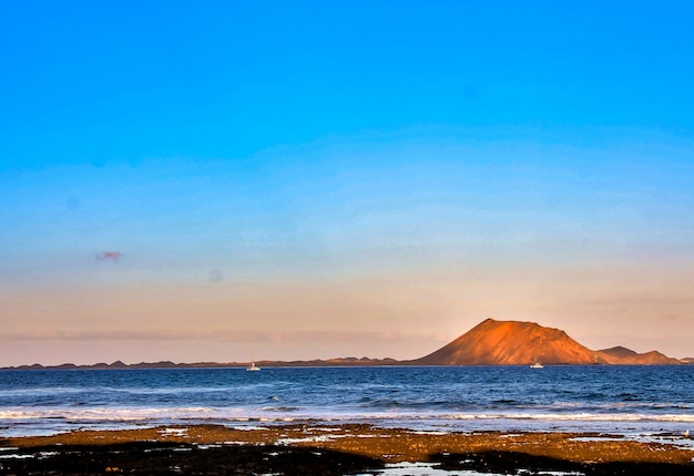 Hermoso paisaje del mar rodeado de colinas durante la puesta de sol