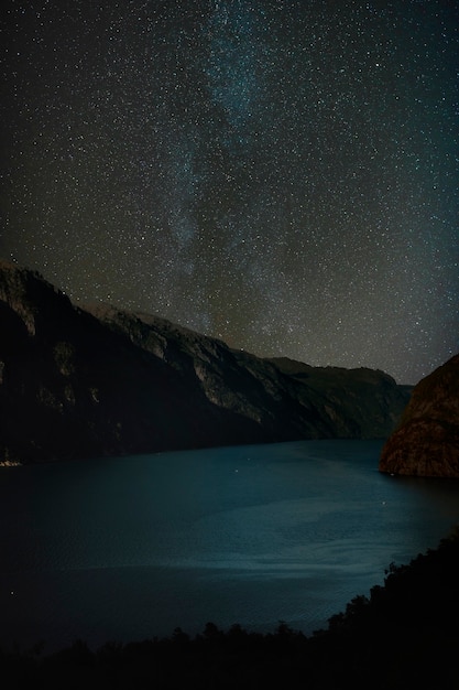 Foto gratuita hermoso paisaje con montaña y cielo estrellado.