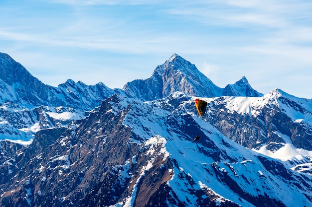 Hermoso paisaje de montañas cubiertas de nieve con un parapente en el Tirol del Sur, Dolomitas, Italia