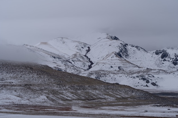 Hermoso paisaje de montañas nevadas en un día sombrío oscuro
