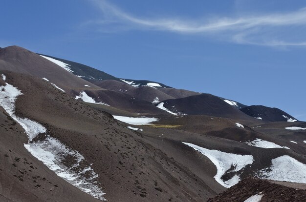 Hermoso paisaje montañoso parcialmente cubierto de nieve bajo un cielo brillante