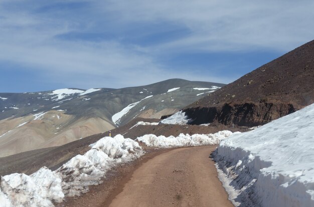 Hermoso paisaje montañoso parcialmente cubierto de nieve bajo un cielo brillante