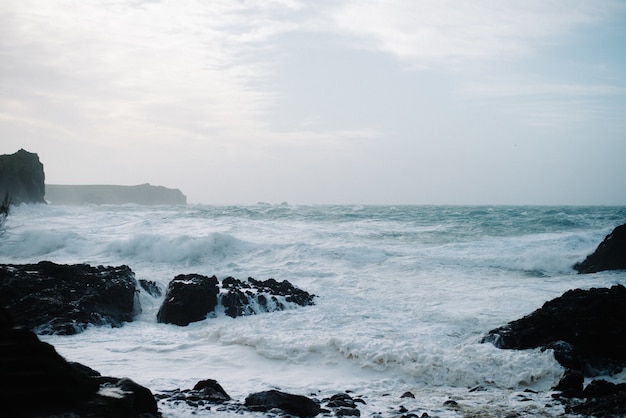 Hermoso paisaje de olas del mar rompiendo sobre formaciones rocosas
