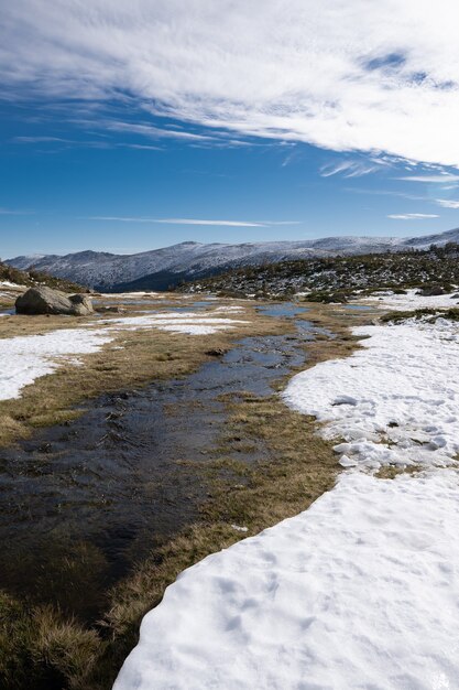 Hermoso paisaje de un paisaje cubierto de nieve con acantilados rocosos bajo un cielo nublado