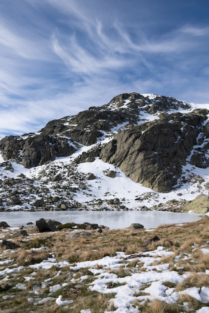 Hermoso paisaje de un paisaje cubierto de nieve con acantilados rocosos bajo un cielo nublado