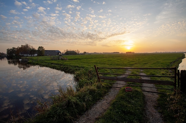 Hermoso paisaje de un paisaje de pólder holandés durante la puesta de sol