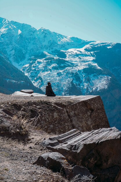 Hermoso paisaje con una persona solitaria mirando montañas cubiertas de nieve en el punto de suicidio en Kalpa