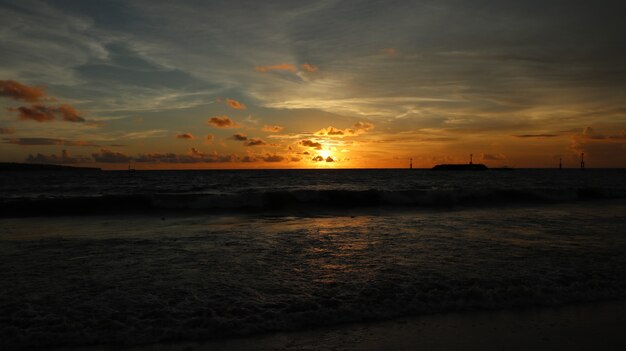 Hermoso paisaje en la playa con puesta de sol y nubes en Bali, Indonesia