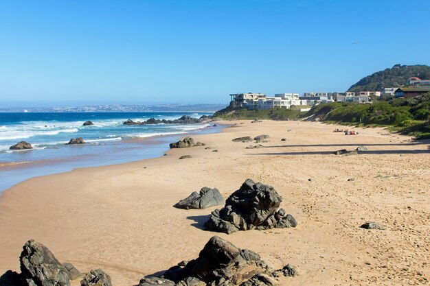 Hermoso paisaje de una playa rodeada de colinas bajo el cielo despejado