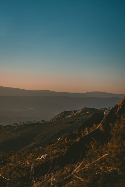 Hermoso paisaje de la puesta de sol sobre un paisaje verde con montañas rocosas