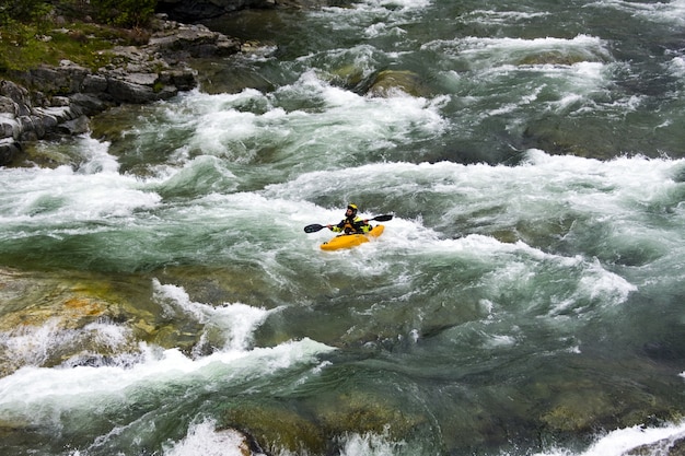 Hermoso paisaje del rafting en la corriente del río de montaña que fluye hacia abajo entre enormes piedras