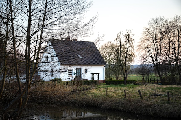 Hermoso paisaje rural con una casa junto al estanque entre los árboles.