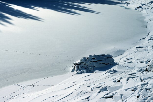 Hermoso paisaje de tierra cubierta de nieve con grietas en los Dolomitas