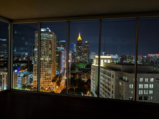 Hermoso paisaje urbano con edificios densos y luces iluminadas desde la ventana por la noche