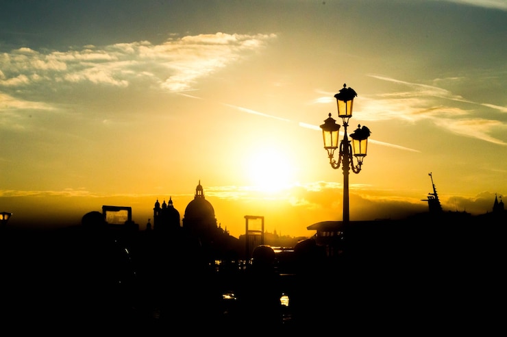 Foto gratuito hermoso paisaje urbano con siluetas de una farola y edificios en la puesta de sol