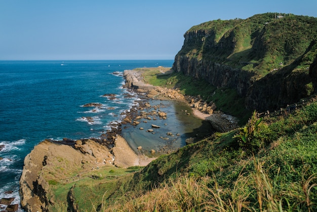 Hermoso paisaje de verdes colinas y formaciones rocosas cerca del mar