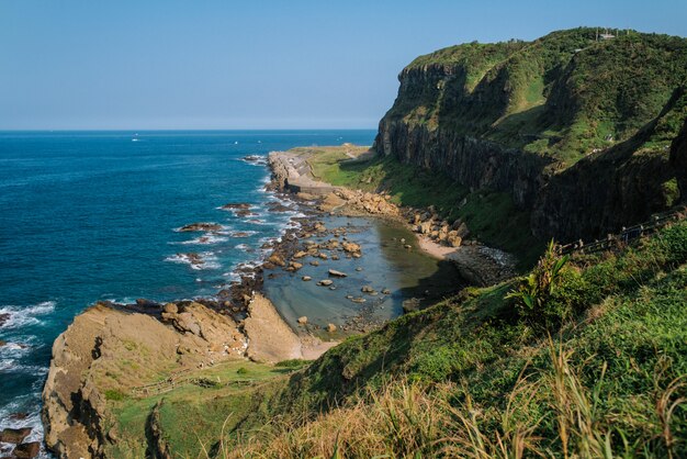 Hermoso paisaje de verdes colinas y formaciones rocosas cerca del mar