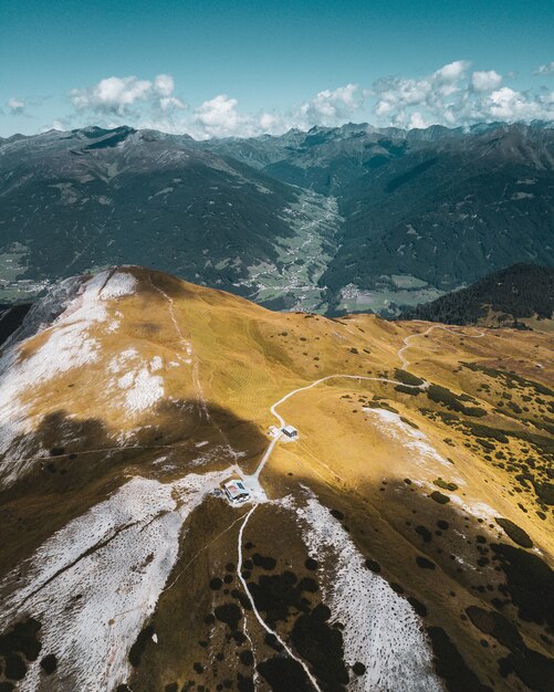 Hermoso paisaje vertical a vista de pájaro de montañas y una casa solitaria