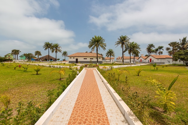 Hermoso pavimento y las casas rodeadas de campos de hierba capturados en Gambia, África