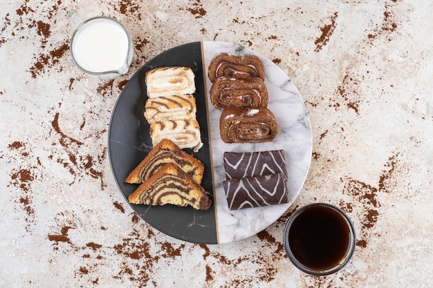 Un hermoso plato con dulces y vasos de bebida.