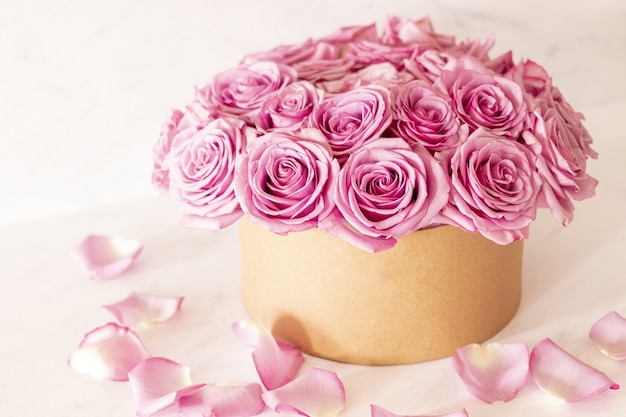 Hermoso ramo floral con rosas rosadas en una caja sobre un fondo rosa