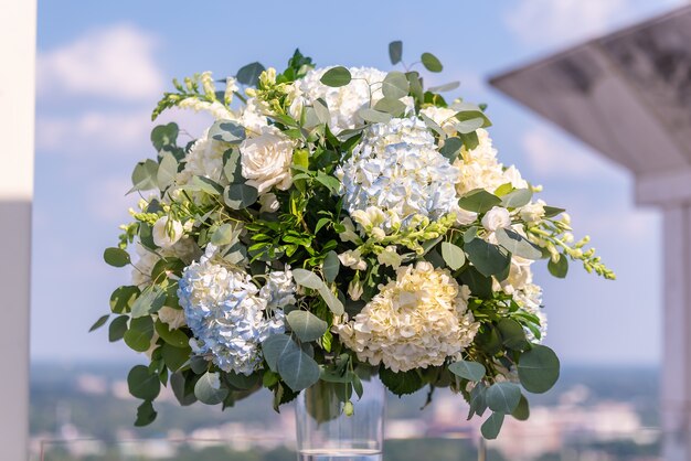 Hermoso ramo de flores blancas en un jarrón durante una ceremonia de boda