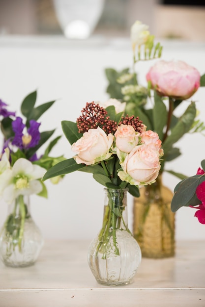 Hermoso ramo de flores en florero sobre mesa