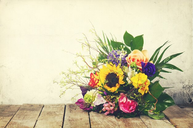 Hermoso ramo de flores en el fondo de madera. Horizontal. Vintage tonificación.