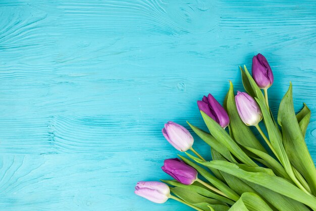 Hermoso ramo de flores de tulipán en superficie turquesa