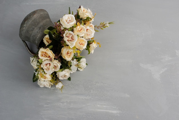 Hermoso ramo de rosas blancas sobre superficie gris