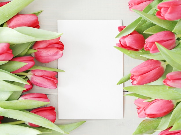 Hermoso ramo de tulipanes con tarjeta de felicitación blanca en blanco